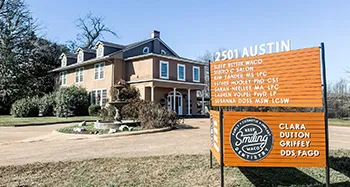 Sign outside of Keep Smiling Waco with the address and doctors' names